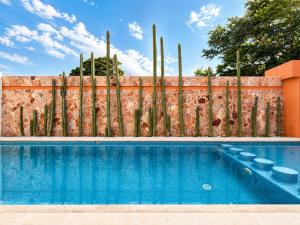 a swimming pool in front of a fence at La Aurora Puerto Escondido in Puerto Escondido