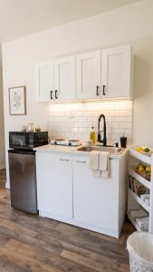 a kitchen with white cabinets and a sink at Charming And Cozy Studio In Oleander Sunset in Bakersfield