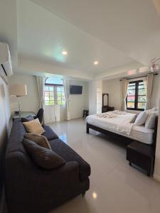 a large bedroom with a bed and a couch at Loy Manee House in Phra Nakhon Si Ayutthaya