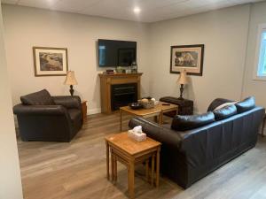 a living room with two leather couches and a tv at Burk Fall view 3B3B in Burks Falls