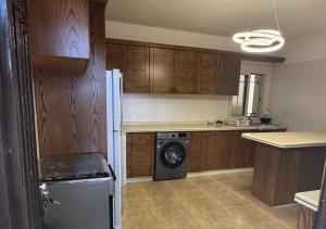 a kitchen with wooden cabinets and a washing machine at Mountain Escape with Rooftop in Jūrat Arşūn