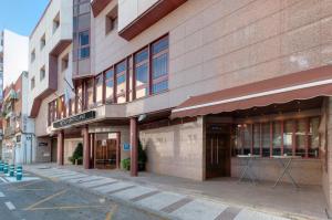 a building on a city street with a building at Hotel Puertollano in Puertollano +20 photos