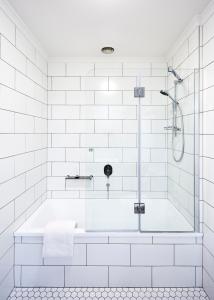 a white bathroom with a tub and a shower at The Terrace at The Settlement in Cranbourne