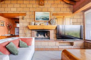 a living room with a large television and a fireplace at Rustic house with stunning lake view in Valle de Bravo