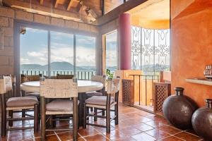 a dining room with a table and chairs and a large window at Rustic house with stunning lake view in Valle de Bravo