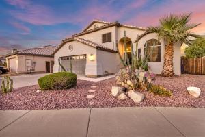 a white house with a palm tree and a driveway at Sparkling SaltwtrPoolSpaFirepitFreeNetflixWiFi in Phoenix