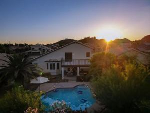 a house with a swimming pool in front of a sunset at Sparkling SaltwtrPoolSpaFirepitFreeNetflixWiFi in Phoenix
