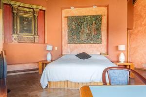 a bedroom with a bed and a painting on the wall at Rustic house with stunning lake view in Valle de Bravo +79 photos