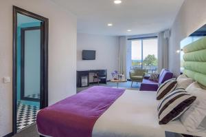 a bedroom with a large bed and a living room at Hotel Eetu Begur, Affiliated by Meliá in Begur