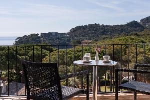 a table and two chairs on a balcony with a view at Hotel Eetu Begur, Affiliated by Meliá in Begur