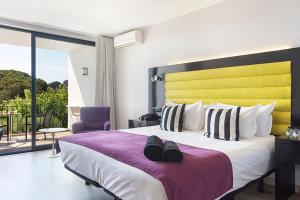a bedroom with a large bed with a yellow headboard at Hotel Eetu Begur, Affiliated by Meliá in Begur +23 photos