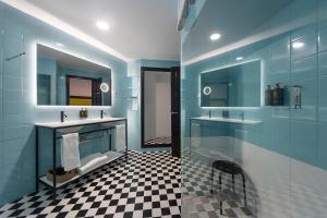 a blue bathroom with two sinks and two mirrors at Hotel Eetu Begur, Affiliated by Meliá in Begur