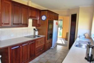 a kitchen with wooden cabinets and a counter top at Seaside Haven in Port Welshpool