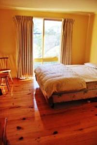 a bedroom with a bed and a large window at Seaside Haven in Port Welshpool