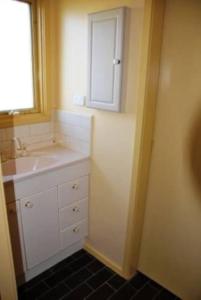 a small bathroom with a sink and a mirror at Seaside Haven in Port Welshpool