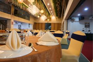 a table with white napkins and chairs in a restaurant at Greenmont Hotel & Apartment in Bandar Seri Begawan