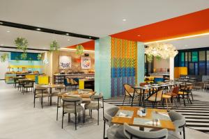 a restaurant with tables and chairs and a bar at Quest Vibe Dewi Sri Bali in Legian