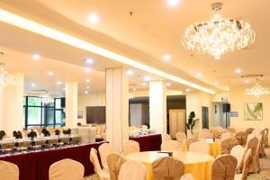 a banquet hall with tables and chairs and a chandelier at Greenmont Hotel & Apartment in Bandar Seri Begawan
