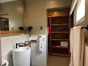 a bathroom with a white sink and a refrigerator at Txaleta de Camiguin desde 2024 in Mambajao