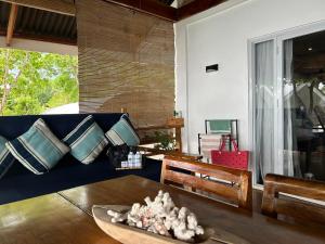 a living room with a blue couch and a table at Txaleta de Camiguin desde 2024 in Mambajao