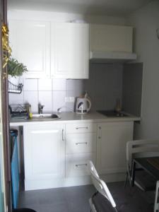 ベネツコにあるBenecko 131の白いキャビネットとシンク付きのキッチン