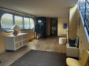 a living room with wooden floors and a living room with a staircase at Peniche Casa Luze in Issy-les-Moulineaux