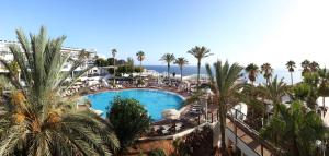 an overhead view of a resort swimming pool with palm trees at Sandos Papagayo in Playa Blanca