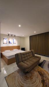 a large bedroom with a bed and a couch at The W Residence in Jakarta