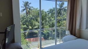 a bedroom with a bed and a large window at Blue Flamingo Kite Beach in Cabarete