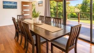 a dining room with a wooden table and chairs at Bawley Backyard Haven - family retreat near beach in Bawley Point