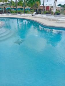 a large pool of blue water with chairs and umbrellas at Le Bunga'Zen in Grand-Bourg +9 photos