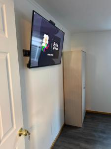 a flat screen tv on a wall next to a door at Casa monje Patagonia in Puerto Natales