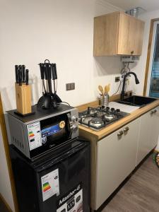 a kitchen with a stove top oven next to a counter at Casa monje Patagonia in Puerto Natales