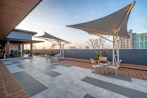 a rooftop patio with chairs and umbrellas on a building at Oakwood Merdeka Bandung in Bandung