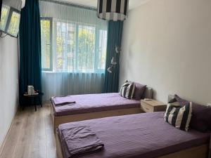 a bedroom with two beds and a window at Апартамент Кари in Yambol