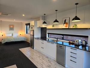 a kitchen with white cabinets and a bed in a room at Simply Stunning Stars A in Lake Tekapo