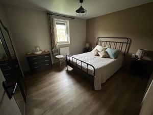 a bedroom with a bed and a dresser and a window at Le chaumet in SAINT DENIS EN MARGERIDE