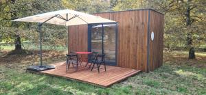 a tiny house with a table and chairs on a deck at Modulbois studio castelnau in Castelnau-de-Médoc