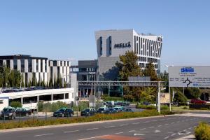 a parking lot with cars parked in front of a building at Meliá Lisboa Aeroporto in Lisbon