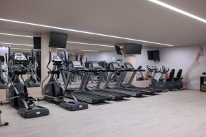 a gym with a row of treadmills and elliptical machines at Meliá Lisboa Aeroporto in Lisbon +17 photos