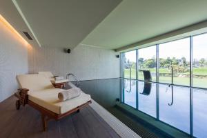a room with a chair and a swimming pool at Meliá Lisboa Aeroporto in Lisbon