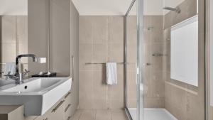 a bathroom with a sink and a tub and a shower at Nautilus - Modern Lakeside Escape in Lakes Entrance +28 photos