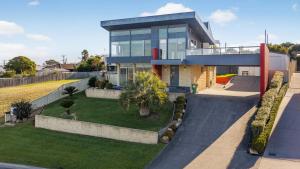 a large house with a yard in front of it at Nautilus - Modern Lakeside Escape in Lakes Entrance