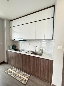 a kitchen with white cabinets and a sink at The Ruby Hạ Long in Ha Long