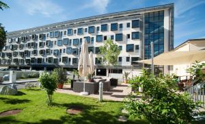 un edificio con césped frente a un edificio en Cityhotel D&C St.Pölten, en Sankt Pölten
