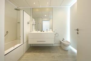 a white bathroom with a sink and a toilet at Sandos Papagayo in Playa Blanca