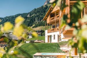 un edificio con piscina frente a una montaña en Lüch de Costa en Colfosco