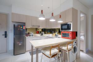 a kitchen with a white table and a refrigerator at Cassia Apartment 1 in Bang Tao Beach