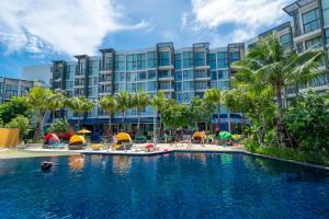 a swimming pool in front of a hotel at Cassia Apartment 1 in Bang Tao Beach