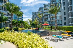 an apartment complex with a swimming pool and palm trees at Cassia Apartment 1 in Bang Tao Beach